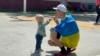 Un padre hace burbujas con su hijo el 6 de abril de 2022 en el polideportivo Benito Juárez en Tijuana, México, que fue convertido en un centro de refugiados para ucranianos. [Foto: VOA / Celia Mendoza]