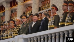 这张朝鲜官方的朝中社(KCNA)于 2023 年 7 月 28 日发布的一张拍摄于 2023 年 7 月 27 日的照片显示，朝鲜领导人金正恩出席纪念朝鲜战争停战70周年的阅兵式。俄罗斯国防部长绍伊古和中国全国人大常委会副委员长李鸿忠站在他身旁一同观看。
