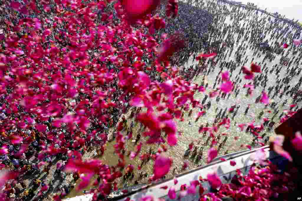 Government officials shower flower petals from a helicopter on to pilgrims gathered at the Sangam, the confluence of three rivers, the Ganges, the Yamuna and the mythical Saraswati, during the Maha Kumbh festival in Prayagraj, India. (AP Photo/Rajesh Kumar Singh)