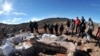 Residents and technicians look at the bones of a dinosaur at a farm in La Flecha, west of Argentina's Patagonian city of Trelew, May 16, 2014. Paleontologists have unearthed in Argentina what they say is the largest set of remains of a dinosaur ever found