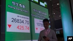 2018年12月5日星期三，一名男子走过香港股票指数电子板。