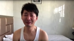 In this image from video taken Feb. 4, 2020 and released by Chen Qiushi, Chinese citizen journalist Chen Qiushi speaks in front of a convention center-turned makeshift hospital amid a viral epidemic in Wuhan in central China's Hubei province. (Courtesy of