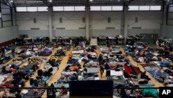 Ukrainian refugees wait in a gymnasium Tuesday, April 5, 2022, in Tijuana, Mexico. (AP Photo/Gregory Bull)
