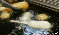 FILE - In this Aug. 8, 2007 file photo, a Milky-Way candy bar is deep-fried in oil free of trans fats at a food booth at the Indiana State Fair in Indianapolis. (AP Photo/Darron Cummings, File)