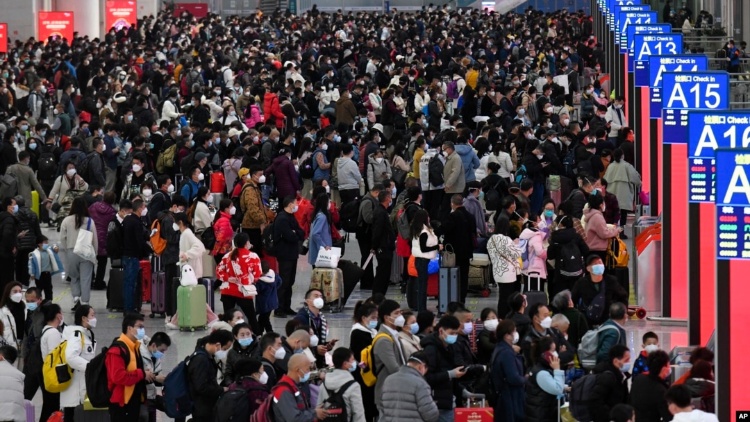 中國交通壓力最大，一年一度的“春運”在如同海嘯般蔓延的新冠感染爆發中拉開帷幕。廣東深圳南站大廳內，旅客帶著口罩和行李，熙熙攘攘擠滿大廳，等待買票和登車。本照片由新華社發布，美聯社提供。
