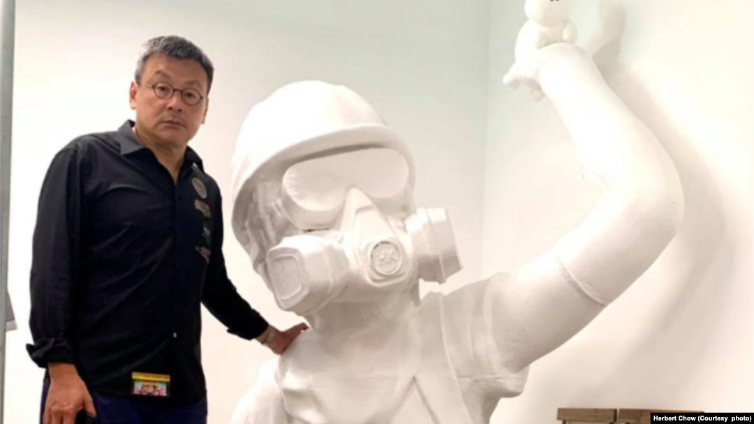 周小龍與巨型雕像合照。(圖片來源：周小龍臉書網站)