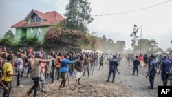 Waandamanaji wakipambana na polisi wakati wakiandamana kupiga uwepo wa vikosi vya kulinda amani vya Umoja wa Mataifa MONUSCO katika Jamhuri ya Kidemokrasia ya Congo , huko Sake, takriban kilomita 24 magharibi ya Goma, July 27, 2022.
