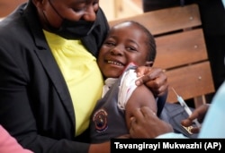 A young girl smiles while been vaccinated against measles at a clinic in Harare, Zimbabwe, Thursday, Sept. 15, 2022. (AP Photo/Tsvangirayi Mukwazhi)