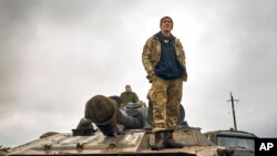 Një ushtar ukrainas qëndron mbi një tank në Kharkivin e çliruar (12 shtator 2022)