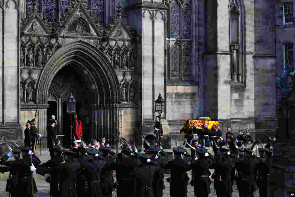 Royal Company of Archers soldiers salute as Queen Elizabeth's coffin arrives at St. Giles' Cathedral on the Royal Mile in Edinburgh, Sept. 12, 2022