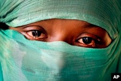 In this Wednesday, Nov. 22, 2017, photo, F, 22, who says she was raped by members of Myanmar's armed forces in June and again in September, is photographed in her tent in Kutupalong refugee camp in Bangladesh.