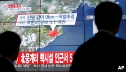 FILE - People walk by a screen showing the news reporting about an earthquake near North Korea's nuclear facility, in Seoul, South Korea, Wednesday, Jan. 6, 2016.