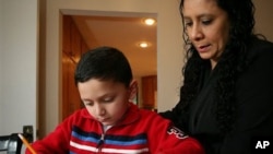Ashton Faller doing homework with his mother last year. Ashton has received treatment for autism since he was two-years-old.