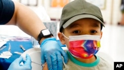 Oliver Estrada, 5, receives the first dose of the Pfizer COVID-19 vaccine at an Adelante Healthcare community vaccine clinic at Joseph Zito Elementary School, Nov. 6, 2021, in Phoenix, Arizona. (AP Photo/Ross D. Franklin)