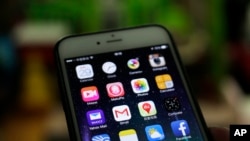 A Gmail mobile app, center left, are seen on a smartphone in Beijing, Dec. 29, 2014. 
