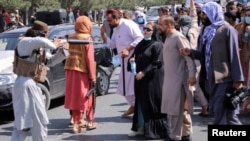 A member of the Taliban forces points his gun at protesters, as Afghan demonstrators shout slogans during an anti-Pakistan protest, near the Pakistan embassy in Kabul, Afghanistan September 7, 2021. (Reuters)