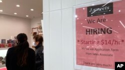 Un cartel de contratación se muestra en una tienda de postres en Arlington Heights, Illinois, el 27 de diciembre de 2022.