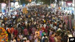 FILE - People crowd a market area outside a train station in Mumbai, India, Saturday, March 12, 2022. (AP Photo/Rajanish Kakade)