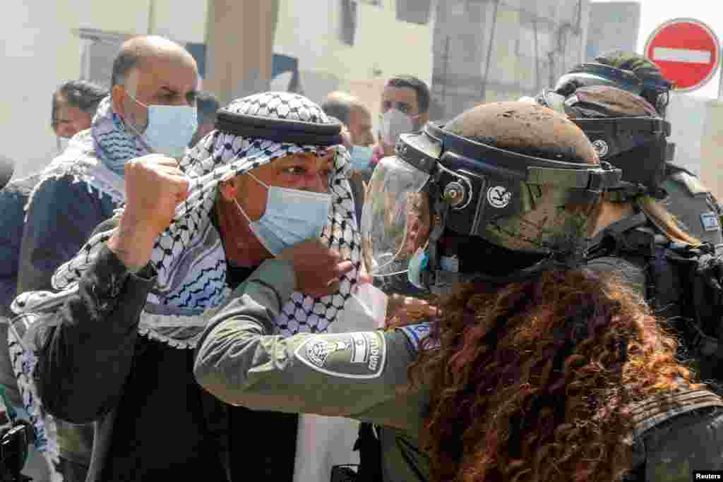 A Palestinian demonstrator scuffles with an Israeli border policewoman during a protest marking "Land Day", in Sebastia near Nablus, in the Israeli-occupied West Bank.