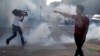 Un manifestante discute con un policía mientras un reportero dispar de gas lacrimógeno durante una manifestación contra la muerte de George Floyd, en Saint Paul, Minnesota.