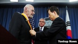한민구 한국 국방부 장관(오른쪽)이 23일 미국 워싱턴 국방부에서 한국전 참전용사인 윌리엄 웨버 미국 육군 예비역 대령에게 '백선엽 한미동맹상'을 수여하고 있다.