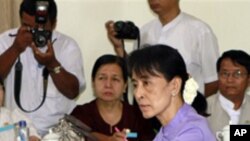 Myanmar pro-democracy icon Aung San Suu Kyi, right in front, accepts candidate list of her National League for Democracy at Yangon District Elections Commission Office for upcoming elections Monday, Feb. 6, 2012 in Yangon, Myanmar. The commission on Monda