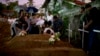Familiares dejan flores en las tumbas de tres víctimas de una misma familia que murieron en los ataques del Domingo de Pascua en la iglesia de St. Sebastian, en Negombo, Sri Lanka, el 22 de abril de 2019.