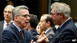 German Interior Minister Thomas de Maiziere, left, speaks with Luxembourg's Foreign Minister Jean Asselborn, right, during a meeting of EU justice ministers at the EU Council building in Brussels, March 10, 2016.