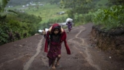 A child carries supplies up a muddy mountainside in Nuevo Queja, Guatemala, Thursday, July 8, 2021. (AP Photo/Rodrigo Abd)