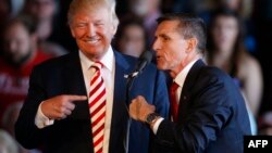 Le président Donald Trump, à gauche, plaisante avec le général à la retraite Michael Flynn lors d'un rassemblement à l'aéroport régional de Grand Junction au Colorado, octobre 2017.
