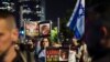 ARCHIVO - Manifestantes levantan pancartas contra la guerra durante una protesta para pedir un alto el fuego en Gaza para conmemorar los 100 días desde el inicio del conflicto entre Israel y el grupo islamista palestino Hamás, en Madrid, España, el 20 de enero de 2024.