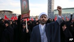 A Muslim cleric chants slogans alongside women in a rally to protest the execution by Saudi Arabia last week of Sheikh Nimr al-Nimr, a prominent opposition Saudi Shiite cleric, in Tehran, Iran, Jan. 4, 2016. (AP Photo/Vahid Salemi)