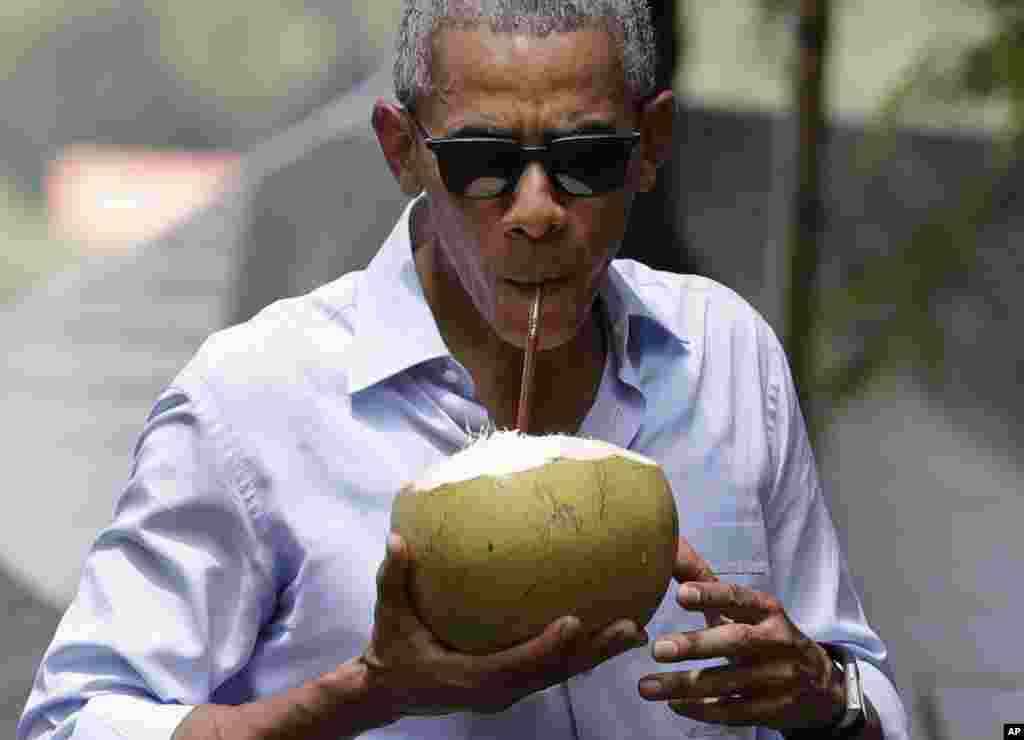 Presiden AS Barack Obama minum kelapa muda segar di dekat Sungai Mekong di Luang Prabang, Laos (7/9). (AP/Carolyn Kaster)
