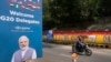 Un motociclista pasa junto a un graffiti en una pared que representa la lucha por la libertad de la India mientras se ve un cartel de bienvenida a los delegados a la izquierda, en Nueva Delhi, India, el 7 de septiembre de 2023.