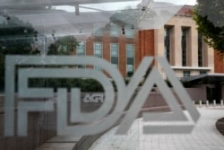 This Aug. 2, 2018, file photo shows the U.S. Food and Drug Administration building behind FDA logos at a bus stop on the agency's campus in Silver Spring, Md. (AP Photo/Jacquelyn Martin, File)
