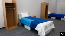 Two sets of bedroom furniture, including cardboard beds, for the Tokyo 2020 Olympic and Paralympic Villages are shown in a display room Thursday, Jan. 9, 2020, in Tokyo. (AP Photo/Jae C. Hong)