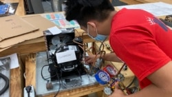 Jacob Torres works on an air compressor at Edison Academy's HVAC classroom.