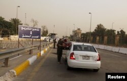 FILE - Iraqi security forces search vehicles at a checkpoint as cars cross into the Green Zone in Baghdad, Iraq, Oct. 5, 2015. The zone houses government buildings and foreign embassies, including that of the United States.
