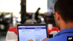 A man demonstrates how he enters his Facebook page as he works on his computer at a restaurant in Brasilia, Brazil, Thursday, Jan. 4, 2018.
