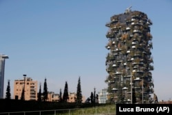 People walk through the Tree Library park in Milan, Italy, Sunday, Dec. 9, 2018. (AP Photo/Luca Bruno)