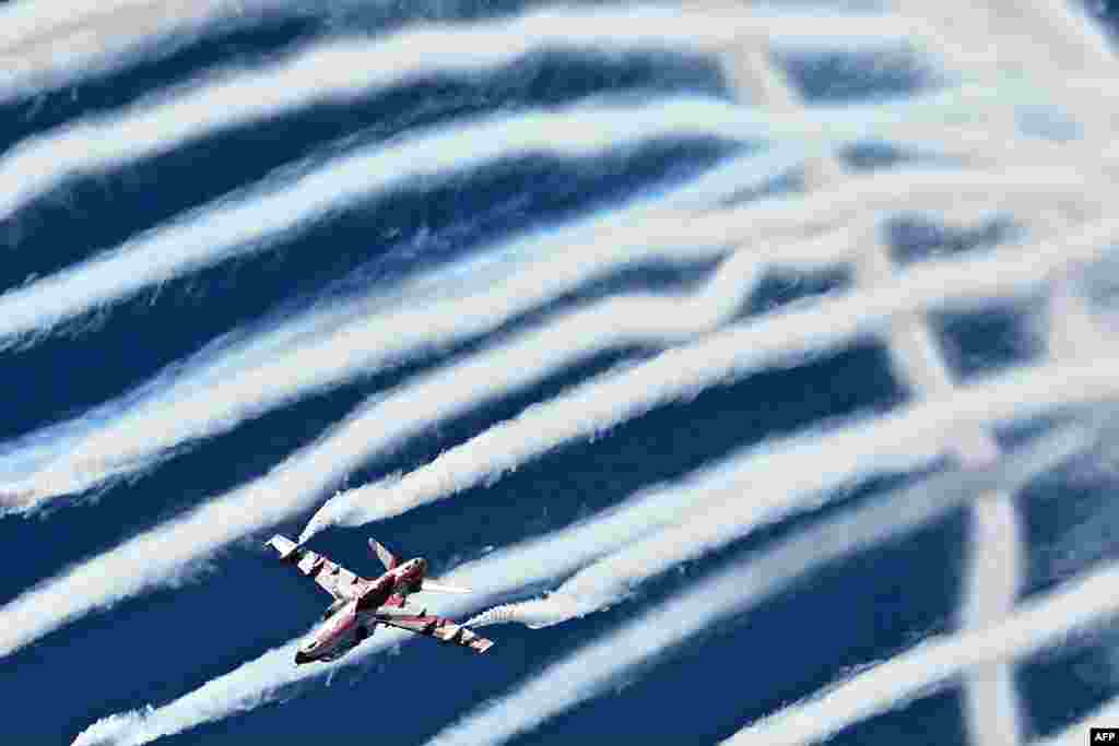 The Indian Air Force Surya Kiran aerobatics team performs during Aero India 2025, a military aviation exhibition at the Yelahanka Air Force Station in Bengaluru. (Photo by Idrees MOHAMMED / AFP)