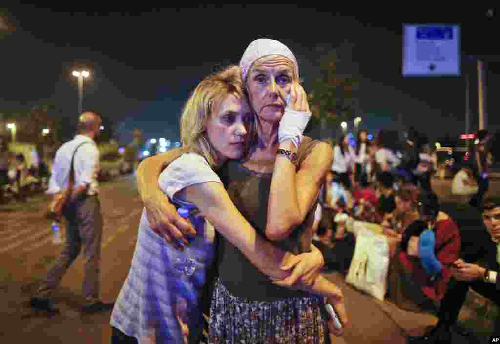 Passengers embrace each other as they wait outside Istanbul's Ataturk airport, June 29, 2016, following their evacuation after a blast. Suspected Islamic State group extremists hit the international terminal of Istanbul's Ataturk airport, killing dozens of people and wounding many others, Turkish officials said.