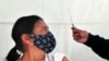 En esta fotografía de archivo del 15 de febrero de 2021, una mujer mira antes de ser vacunada con una dosis de la vacuna AstraZeneca contra COVID-19 en el área de Magdalena Contreras, Ciudad de México.
