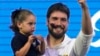 Jan Topic, candidato presidencial, sostiene a su hija mientras sonríe durante un evento el 20 de agosto, en Guayaquil, Ecuador. AP