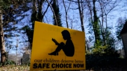 FILE A sign that reads "our children deserve better safe choice now" is seen on Friday, Jan. 15, 2021, in Decatur, Ga. Just down the road from the U.S. Centers for Disease Control and Prevention, in a community flush with resident health professionals, the Decatur school system had no shortage of expert input on whether to resume in-person classes amid the coronavirus pandemic. (AP Photo/Brynn Anderson)