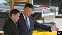 Chinese President Xi Jinping, right, shows the way to Philippine President Rodrigo Duterte during a welcome ceremony outside the Great Hall of the People in Beijing, China, Thursday, Oct. 20, 2016. (AP Photo/Ng Han Guan)