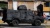 Camión policial blindado patrulla zona donde fue encontrado el cuerpo del exmilitar venezolano Ronald Ojeda, durante un operativo policial contra la organización criminal venezolana Tren de Aragua, en Santiago, Chile, el miércoles 22 de enero de 2025. (AP Foto/Esteban Félix).