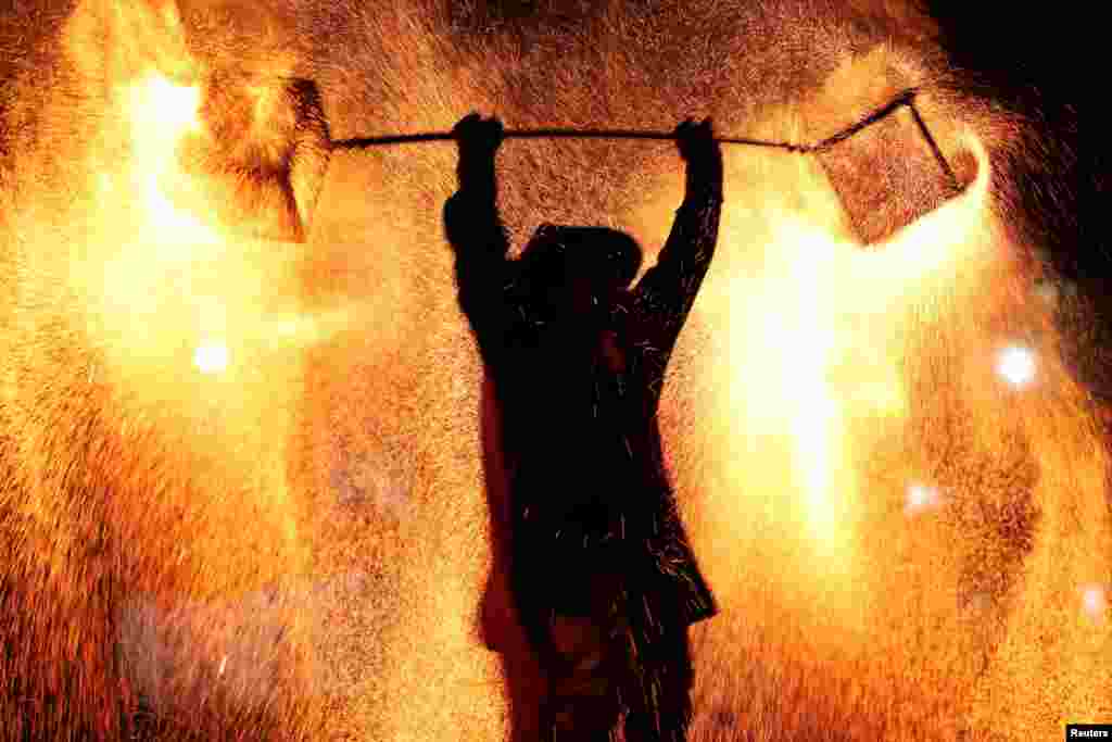 A folk artist takes part in a molten iron fireworks performance at Shanghai Happy Valley amusement park during the Lantern Festival, which marks the end of the Lunar New Year celebrations, in Shanghai, China. REUTERS/Go Nakamura