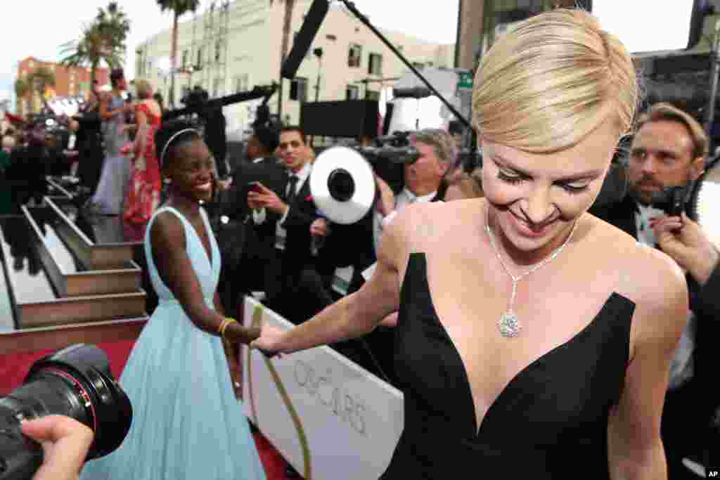 Nữ diễn viên Lupita Nyong'o và Charlize Theron tại lễ trao giải Oscar ở Los Angeles, ngày 2/3/2014.