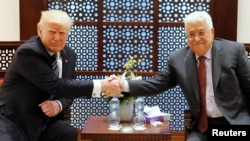 U.S. President Donald Trump (L) and Palestinian President Mahmoud Abbas shake hands before beginning their meeting at the Presidential Palace in the West Bank city of Bethlehem, May 23, 2017.